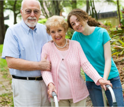 elderly couple with caregiver smiling